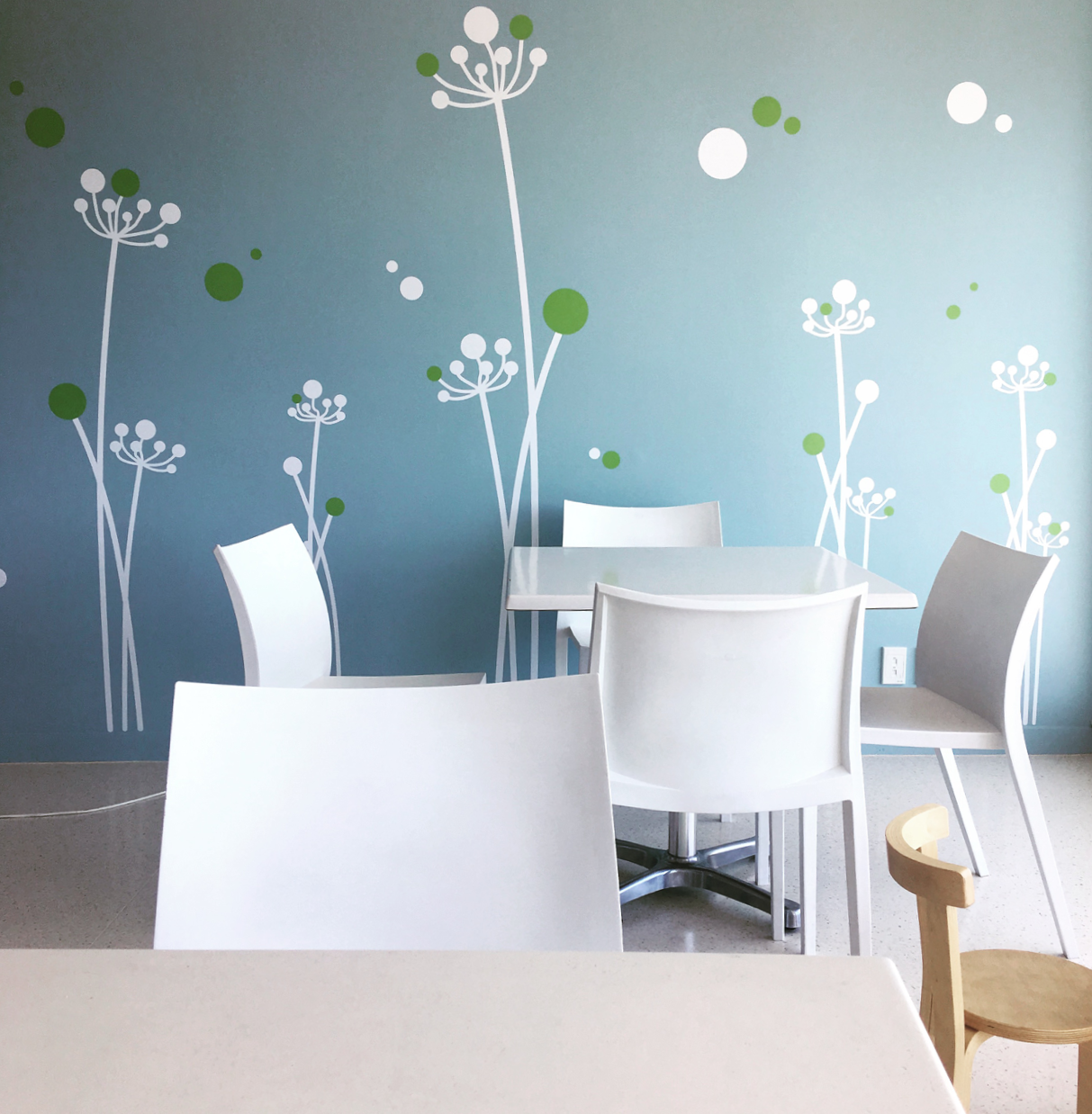 ronald mcdonald house family dining space with white furniture and wall decals
