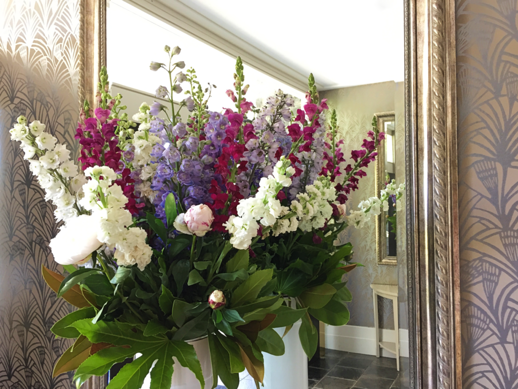 large bunch of colourful flowers in front of gold mirror