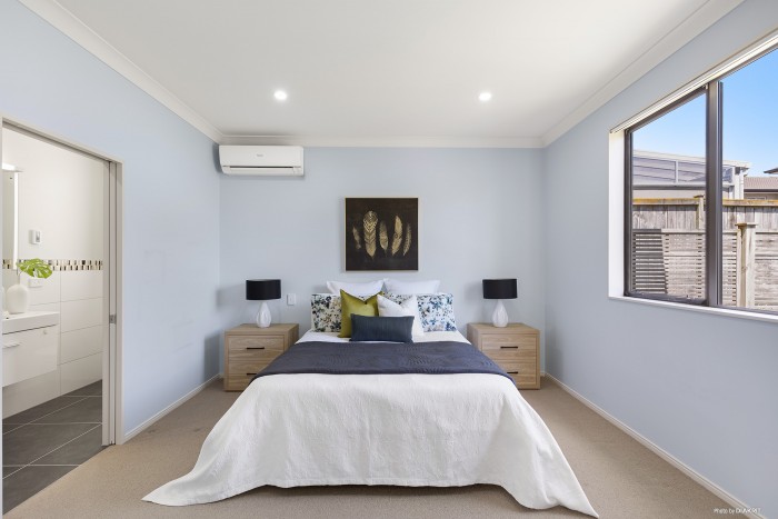 modern bedroom with grey blue and green bedding and light blue walls