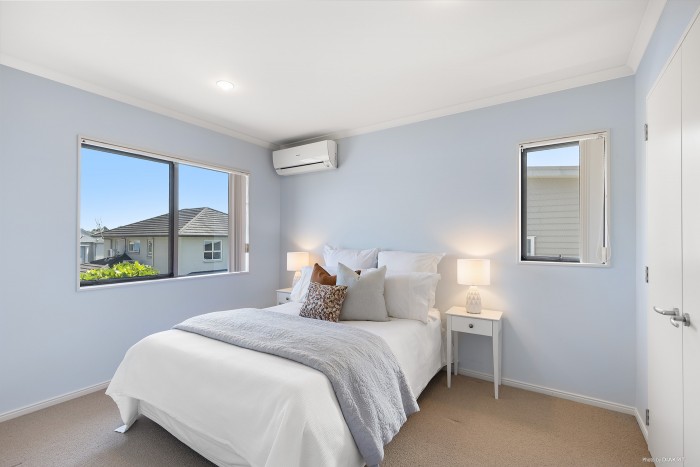 modern bedroom with grey and orange bedding and light blue walls