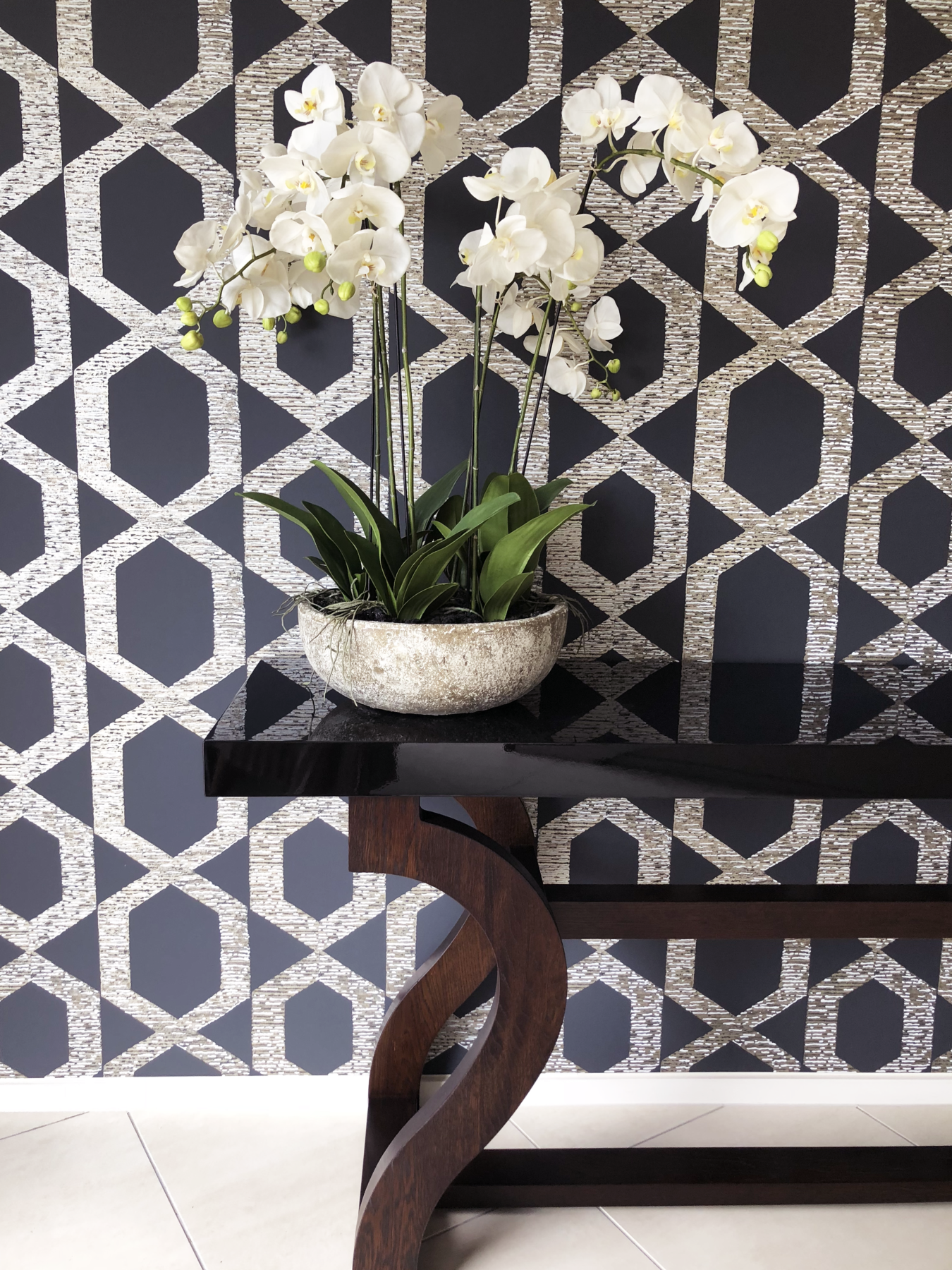glamourous hallway black gloss table with statement dark geometric wallpaper